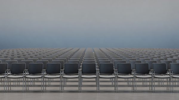 Rows of empty conference session chairs in a large hall, muted gradient background, shallow depth of field